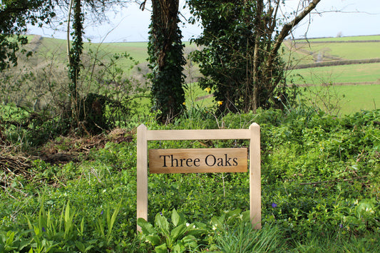 wooden sign with hanging plaque on two posts