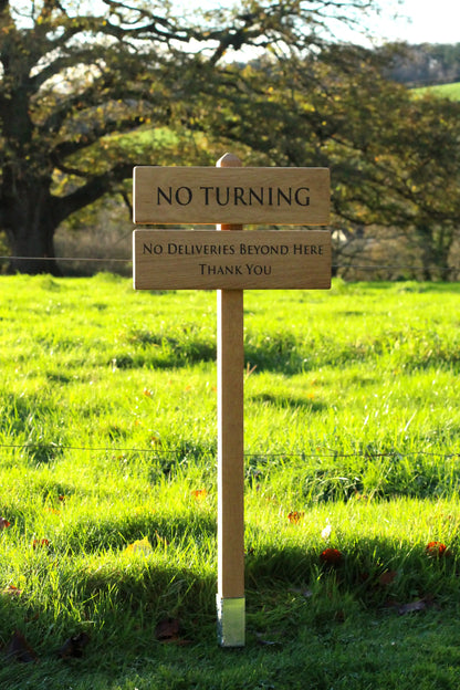 photo of wooden sign with the background of a large oak tree