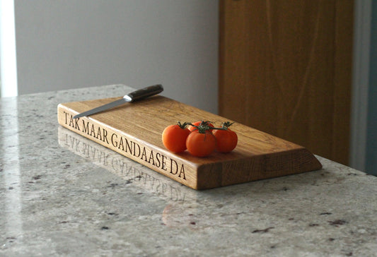 Wooden cutting board with engraved text on a marble countertop