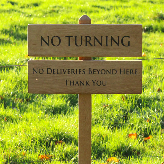 photo of wooden sign with the background of a large oak tree