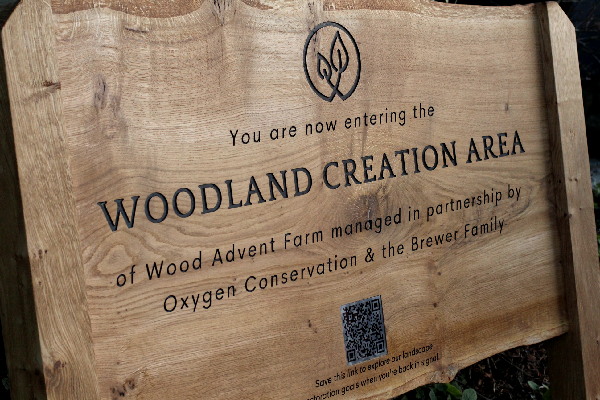 Wooden sign indicating entry to a woodland creation area managed by Wood Advent Farm.