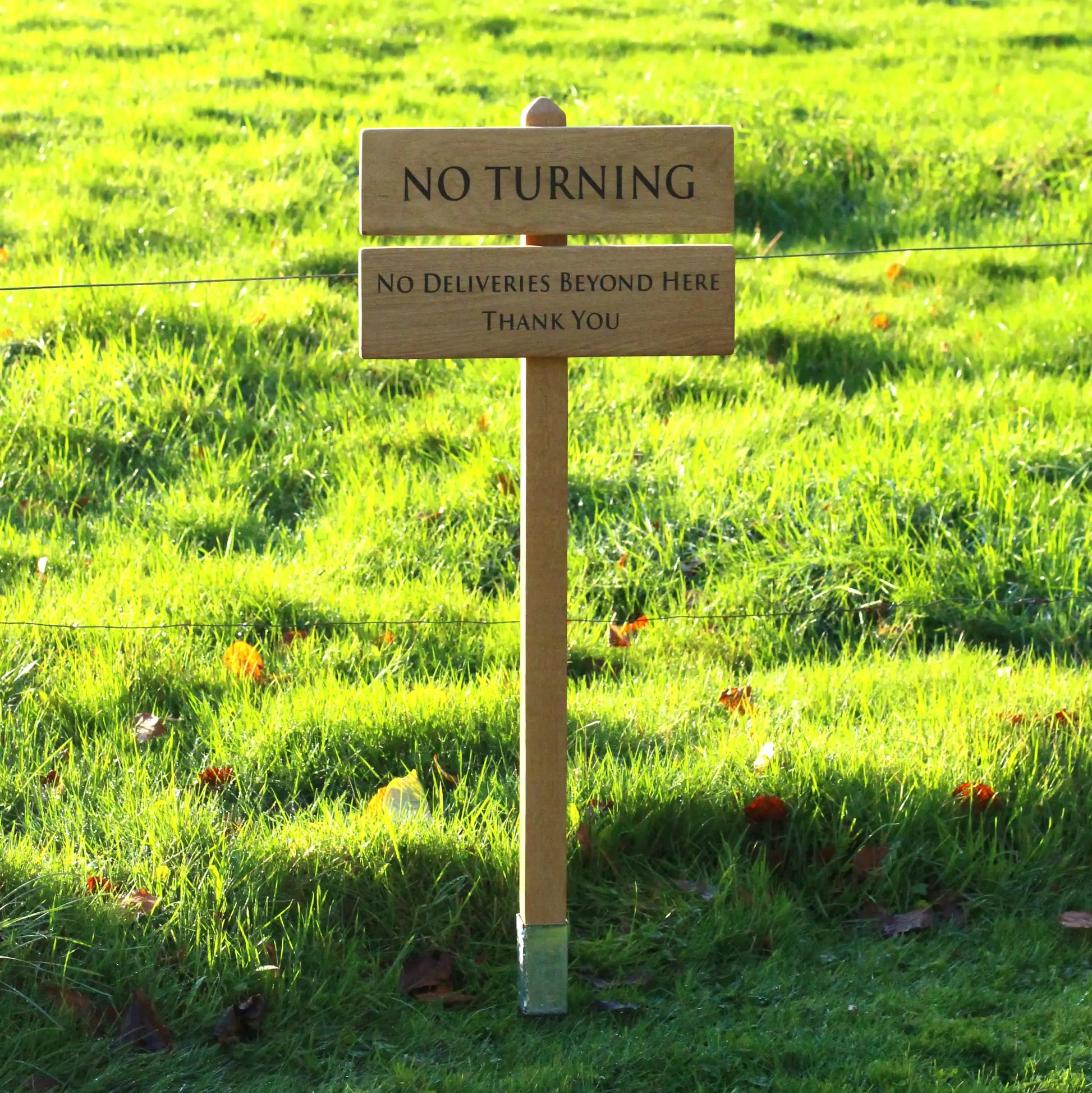 photo of wooden sign with the background of a large oak tree