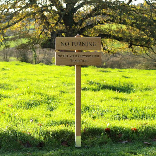 photo of wooden sign with the background of a large oak tree