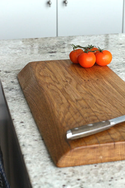 Wooden cutting board on a kitchen counter with tomatoes