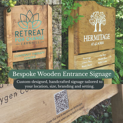 Two wooden entrance signs with branding and text, surrounded by greenery.