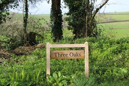 wooden sign with hanging plaque on two posts
